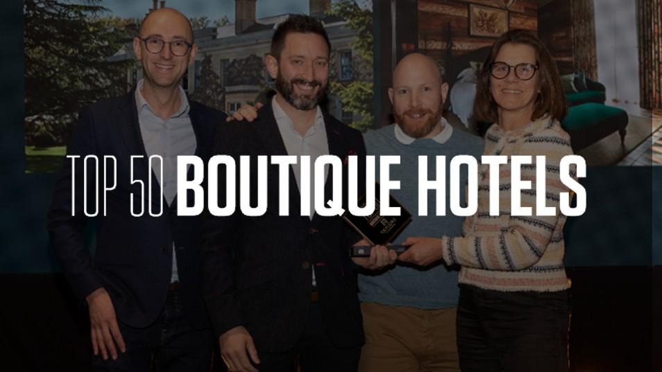 people in suits on stage with top 50 boutique hotels logo over them